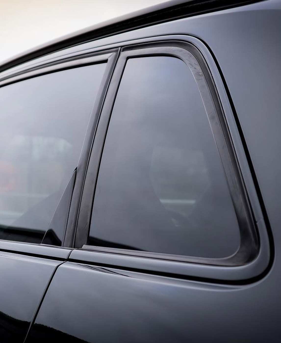 dark window tint on a matte black car close up of back window
